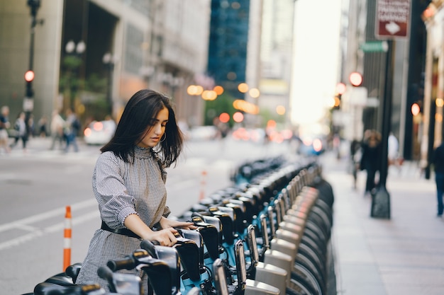 girl renting a city bike from a bike stand