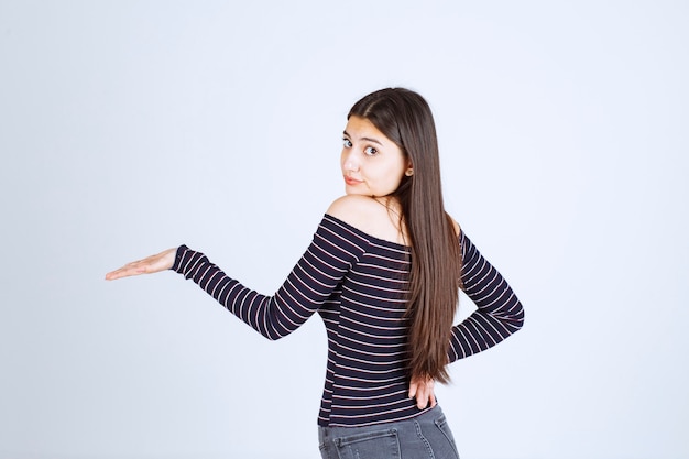 Girl showing something in her open hand. 