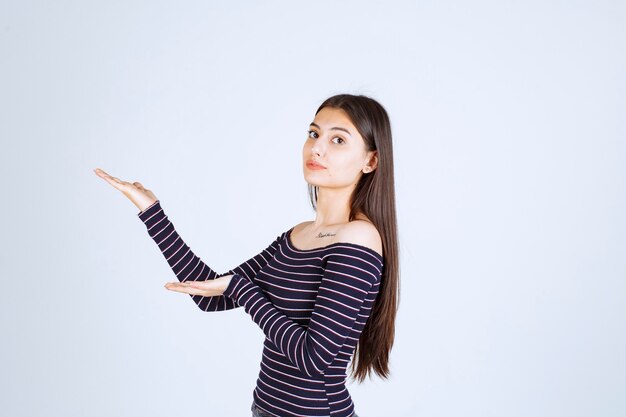 Girl showing something in her open hand. 