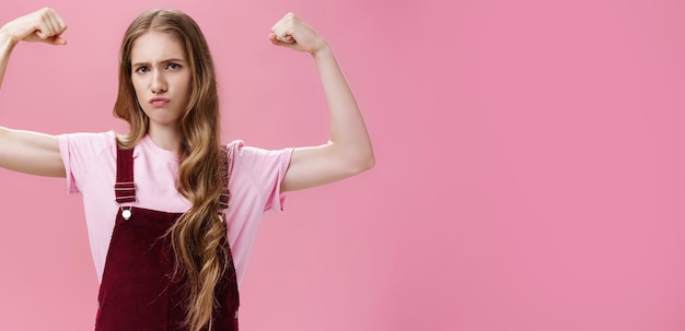 Free photo girl shows she strong and independent seriouslooking confident slender female raising hands to show