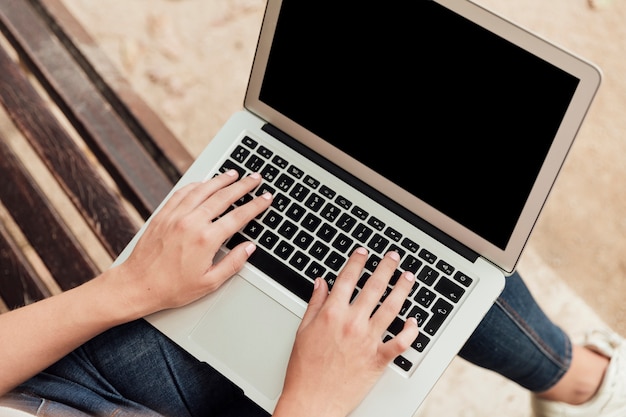 Girl sitting on a bench with a laptop