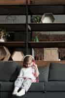 Free photo girl sitting on couch with headphones