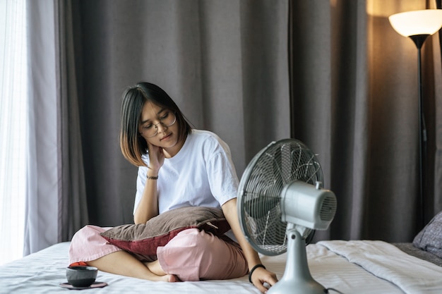 A girl sitting and drinking coffee on the bedroom.