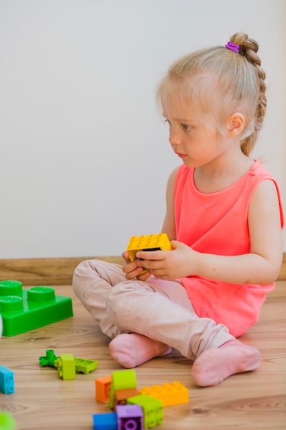 Girl sitting on floor playing with blocks