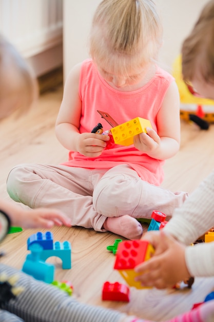 Free photo girl sitting on floor playing with toys