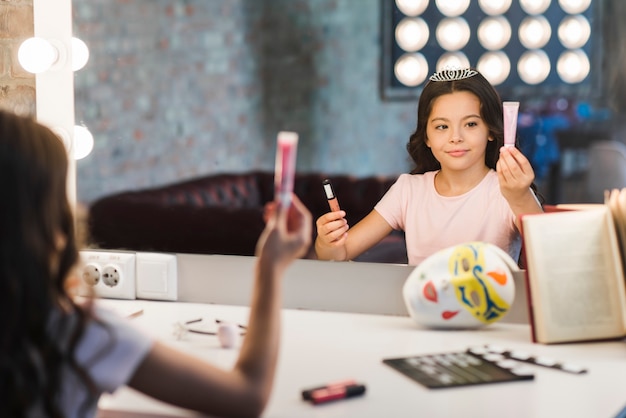 Free photo girl sitting in makeup room choosing cosmetic