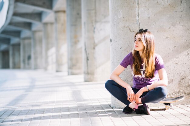 Girl sitting on a skateboard