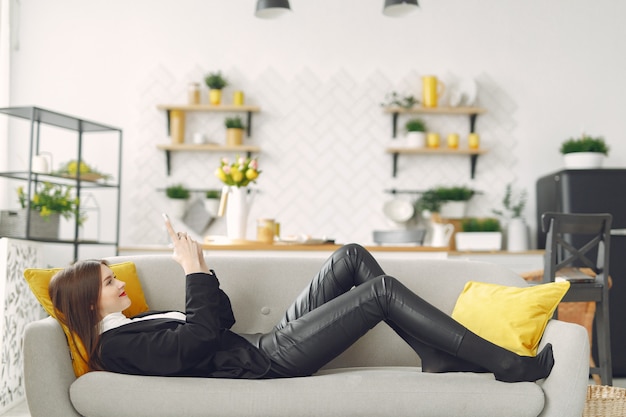 Girl sitting on the sofa and use the phone