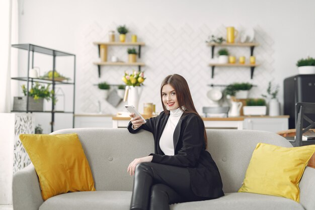 Girl sitting on the sofa and use the phone