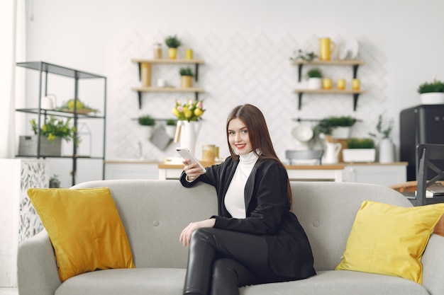 Girl sitting on the sofa and use the phone