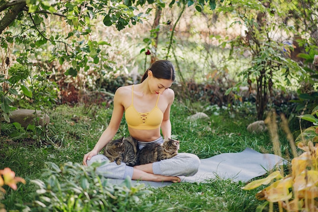 Free photo girl sitting in a summer park with cute cat