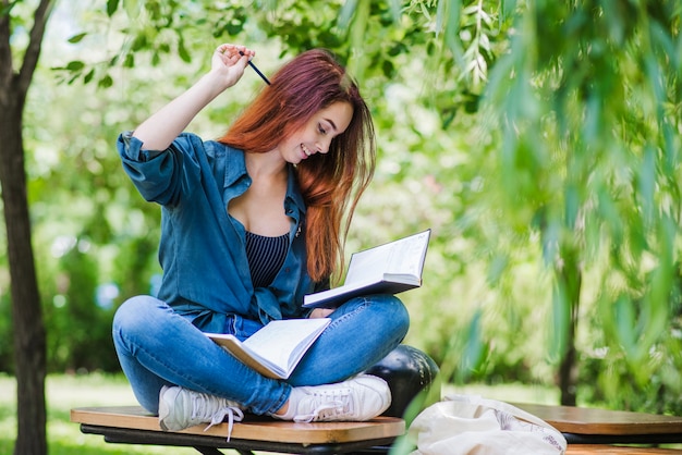 Girl sitting on table in park smiling