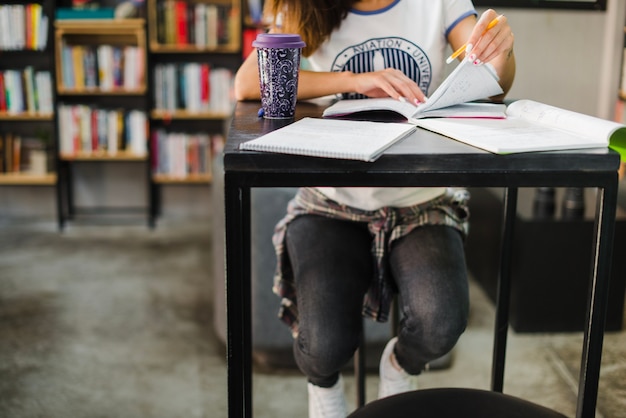 Free Photo girl sitting at table reading