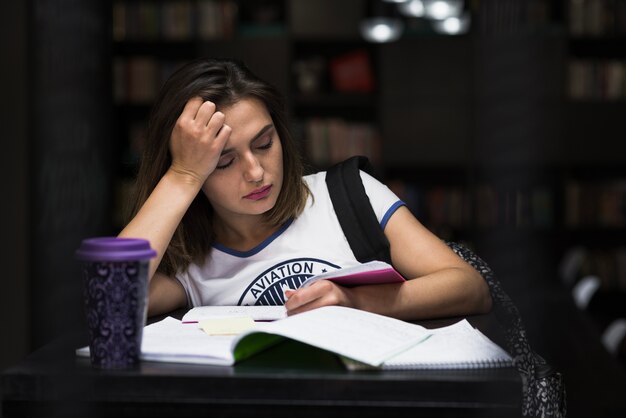 Girl sitting at table with notebooks reading