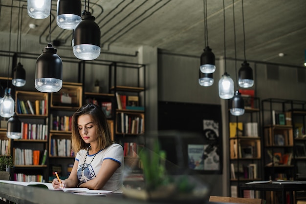 Girl sitting at table writing