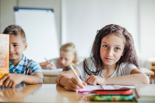 Free photo girl sitting at table writing