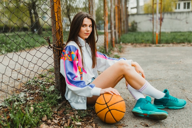 Free photo girl sitting with basketball