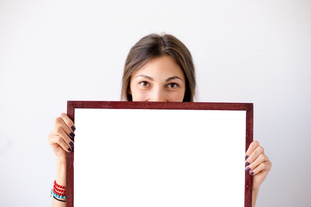 Girl smiling showing blank white placard or poster