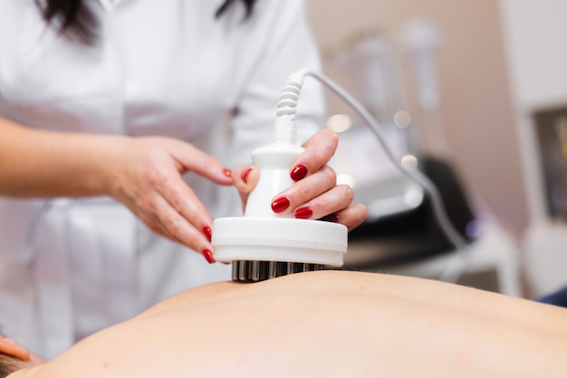 The girl in the spa salon receives a back and neck massage, lies in the cosmetology table, relaxed and enjoys the process