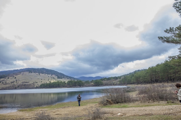 Girl standing near Lake Piva (Pivsko jezero)  with mountain landscape on the distance