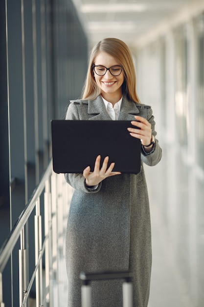 Girl standing in the office with a laptop