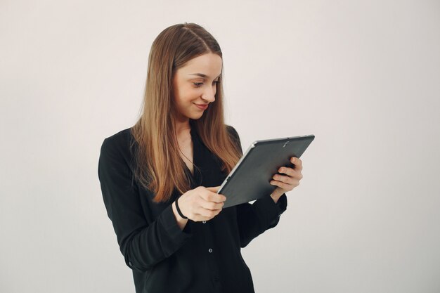 Free Photo girl standing on a white wall with a laptop