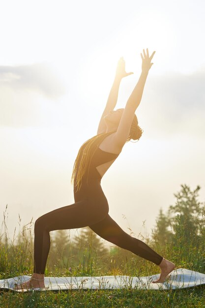 Girl stepping forward on yoga mat in nature