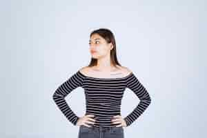 Free photo girl in striped shirt giving neutral poses without reactions.