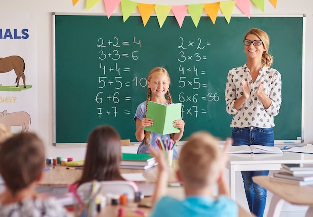 Girl student with clapping teacher 
