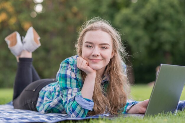 Girl studying with laptop on picnic cloth