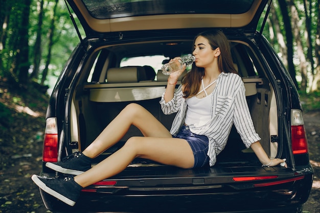 Free photo girl in a summer park near car