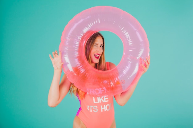 Free Photo girl in swimsuit looking through inflatable ring