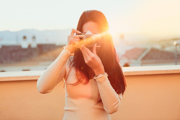 Free photo girl taking a photo with her retro camera