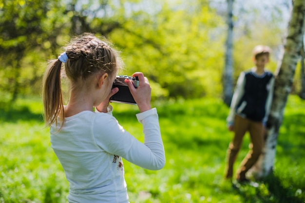 Free photo girl taking a picture of her brother