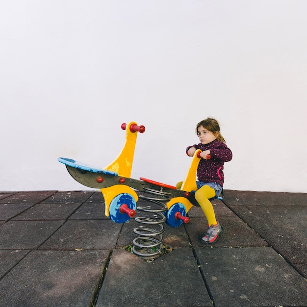 Free photo girl taking ride on seesaw