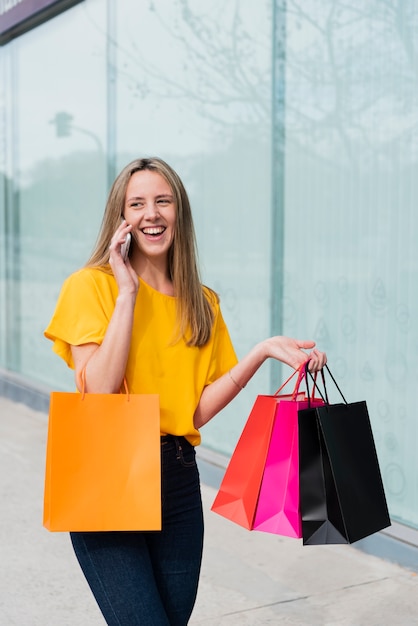 Girl talking on the phone while holding shopping bags