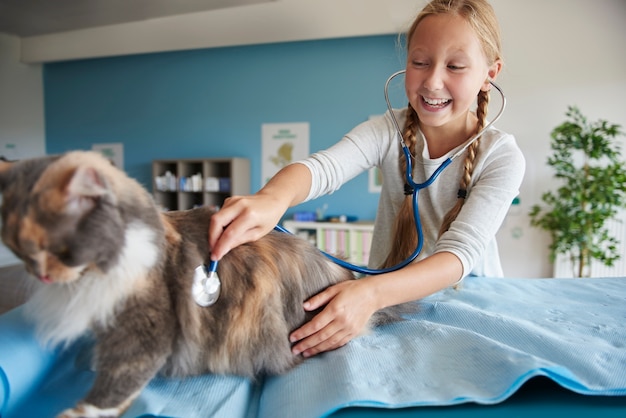 Free Photo girl trying to examine her cat