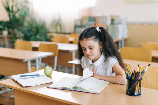 Girl turning page in class