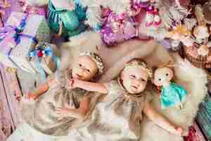 Free photo girl-twins lie under pink christmas tree