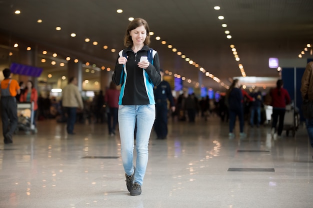 Girl using cell phone in airport