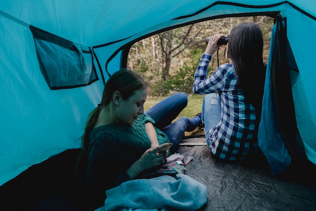 Girl using her binoculars next to her friend