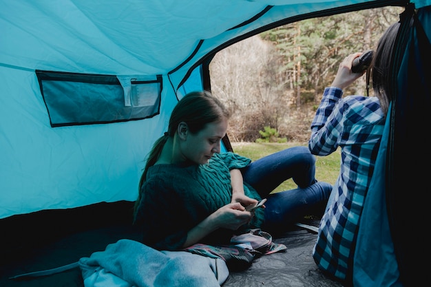 Girl using her cell phone in the tent