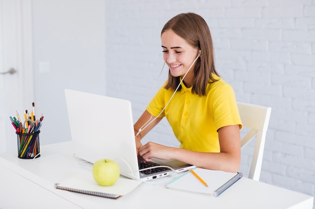 Girl using laptop and listening to music