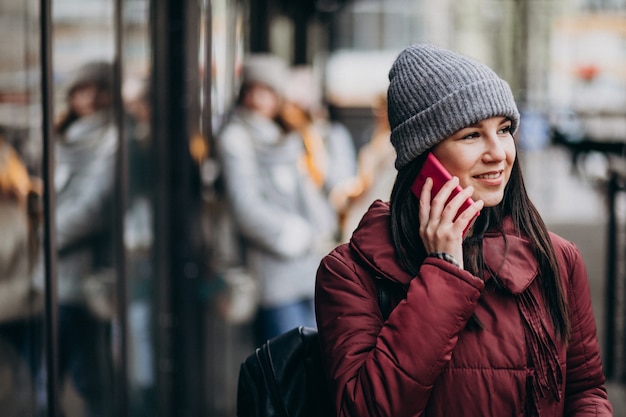 Girl using phone outside the street and meeting with friends