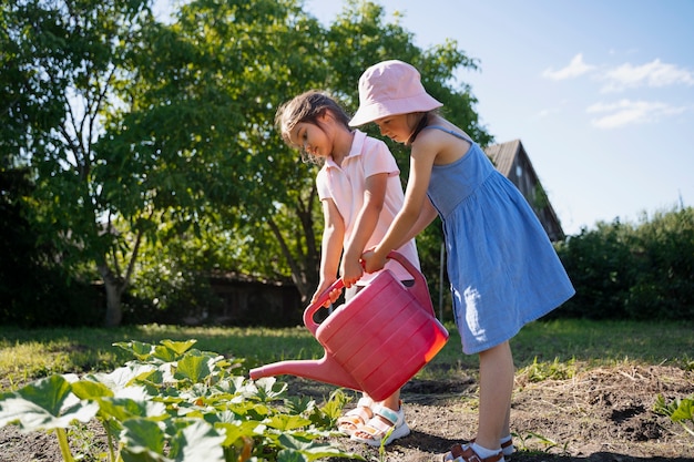 Girl using watering can outdoors in nature