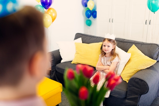 Girl waiting flowers on sofa