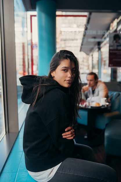 Girl waiting someone who late, looking through the window