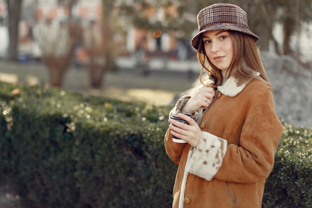 Girl walking in a spring city and taking coffee