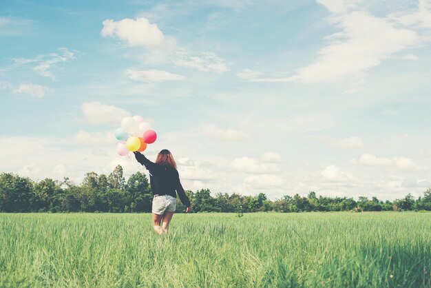 Girl walking with colored ballons