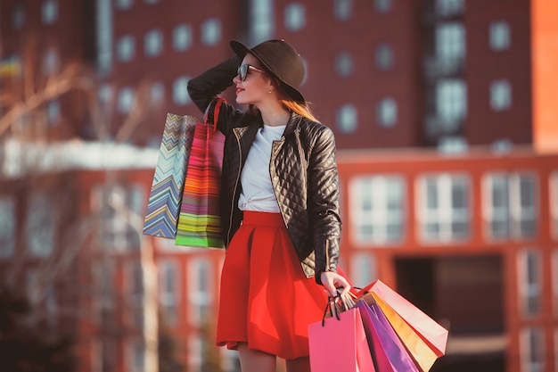 The girl walking with shopping bags on city streets at sunny day